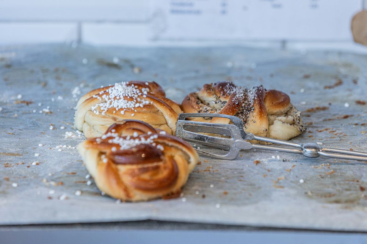 Kanelbullar med pärlsocker på bakplåtspapper