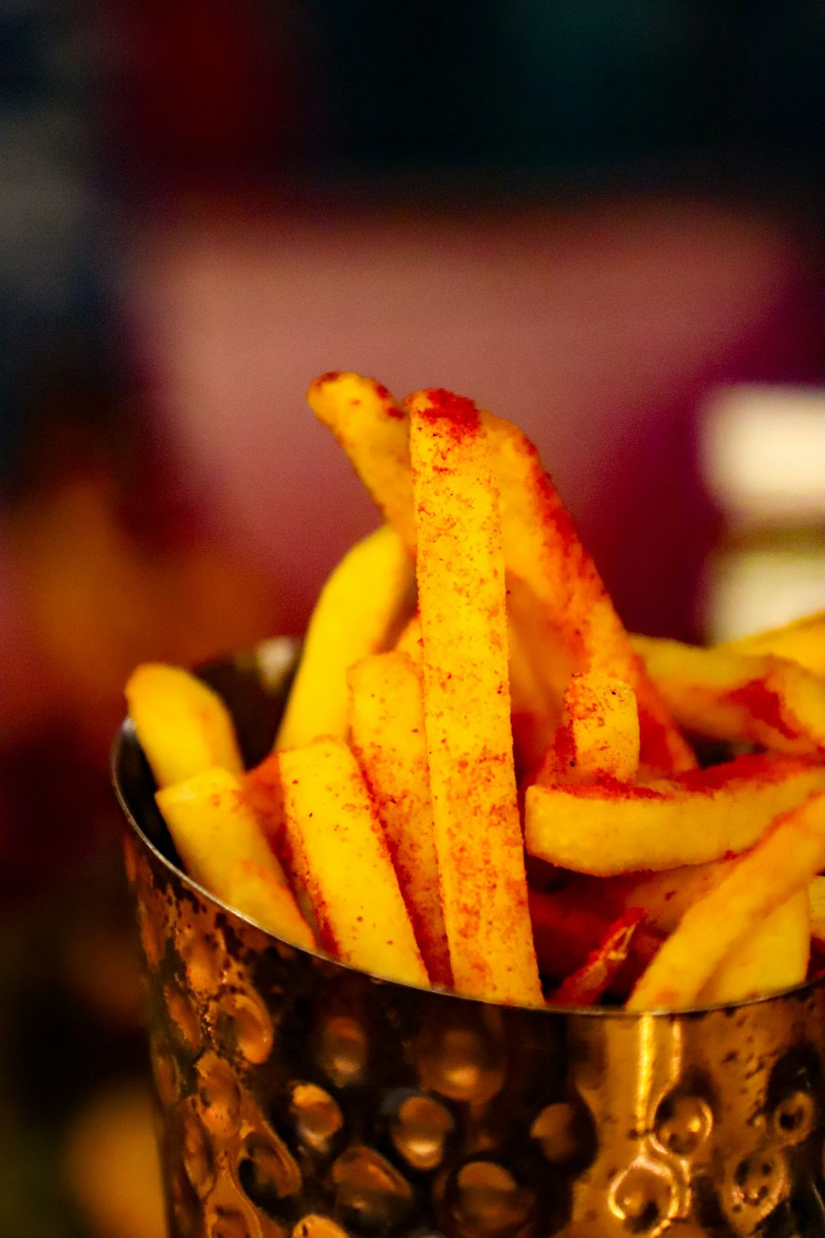 Pommes frites i metallkopp på bord